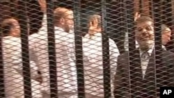 FILE - A Nov. 2013 image made from video provided by Egypt's Interior Ministry shows ousted president Mohammed Morsi (R) in a defendant's cage during a trial hearing in Cairo.