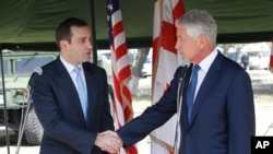 Georgia's Defense Minister Irakli Alasania, left, and U.S. Defense Secretary Chuck Hagel shake hands at the Krtsanisi military training base outside Tbilisi Georgia, Sunday, Sept. 7, 2014. 