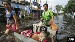 Cư dân băng qua 1 con đường bị ngập lụt ở Bangkok, Thái Lan, Chủ Nhật 23/10/2011