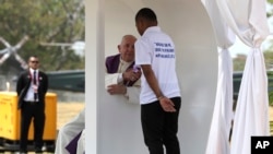 El papa Francisco le da la mano a un preso antes de escuchar su confesión durante una liturgia penitencial en el centro de detención de menores en Las Garzas, en Panamá, el viernes 25 de enero de 2019.