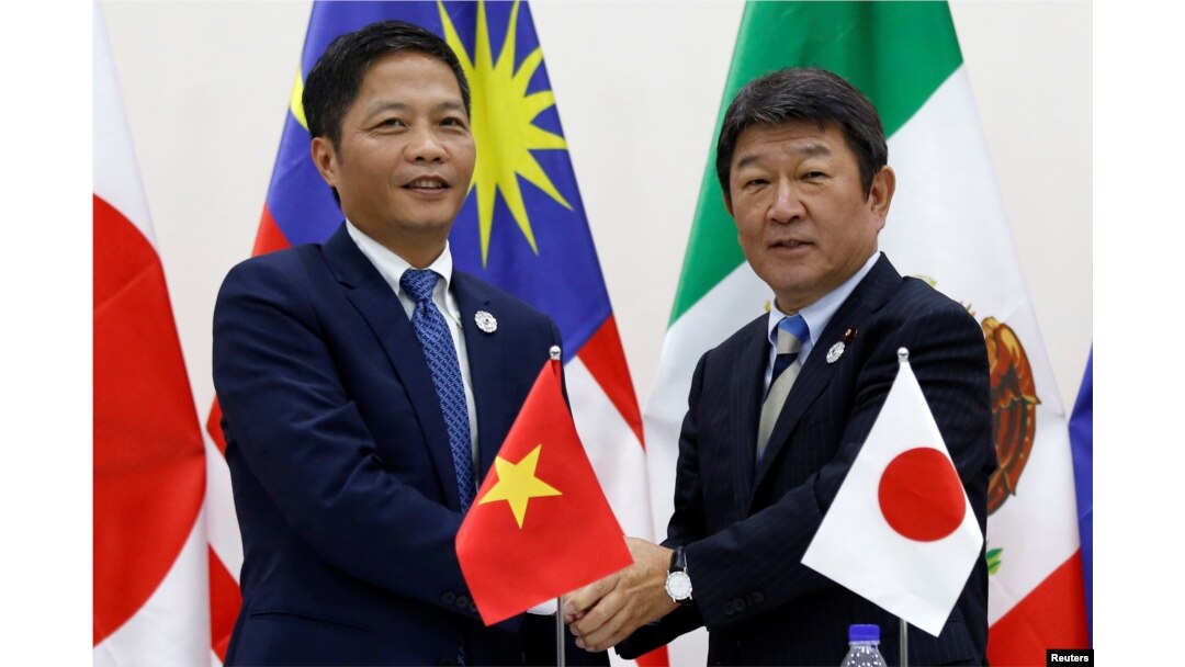 Vietnam's Industry and Trade Minister Tran Tuan Anh, left, and Japan's Minister of Economic Revitalization Toshimitsu Motegi shake hands after a news conference on the Trans Pacific Partnership (TPP) Ministerial Meeting during APEC 2017 in Danang, Vietnam