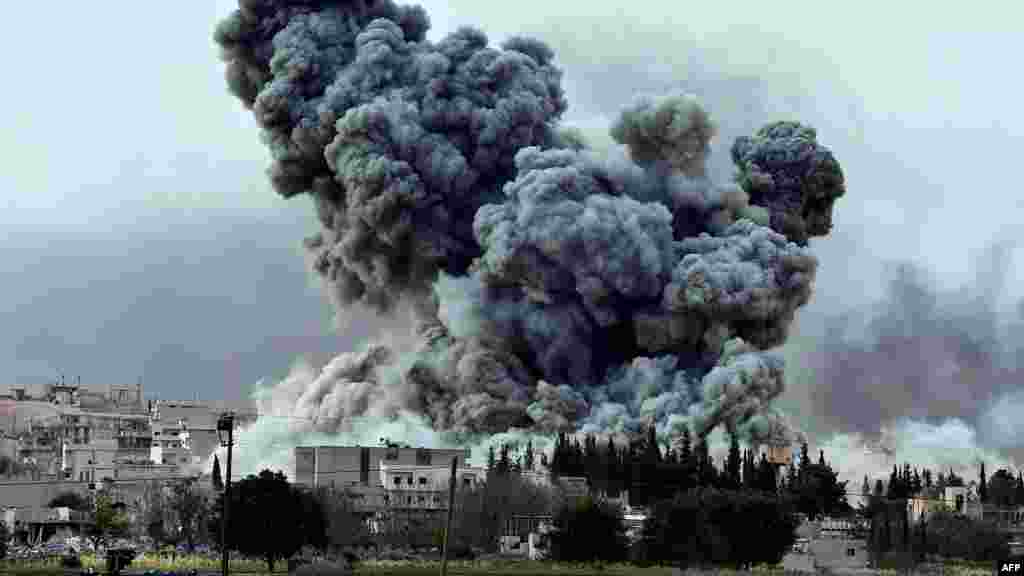 Epaisse fumée et débris s&#39;élèvent après une frappe de la coalition menée oar les Etats-Unis à Kobani, en Syrie, dimanche le 12 ocotbre 2014. (AP Photo/Lefteris Pitarakis) 