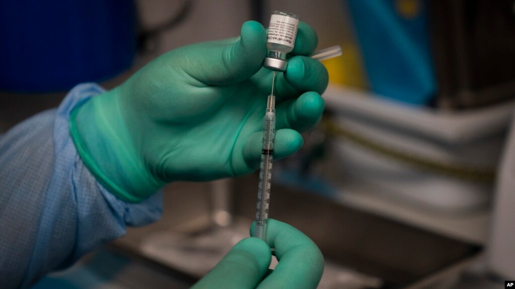 FILE - In this Aug. 26, 2021 file photo, Parsia Jahanbani prepares a syringe with the Pfizer COVID-19 vaccine. (AP Photo/Jae C. Hong, File)