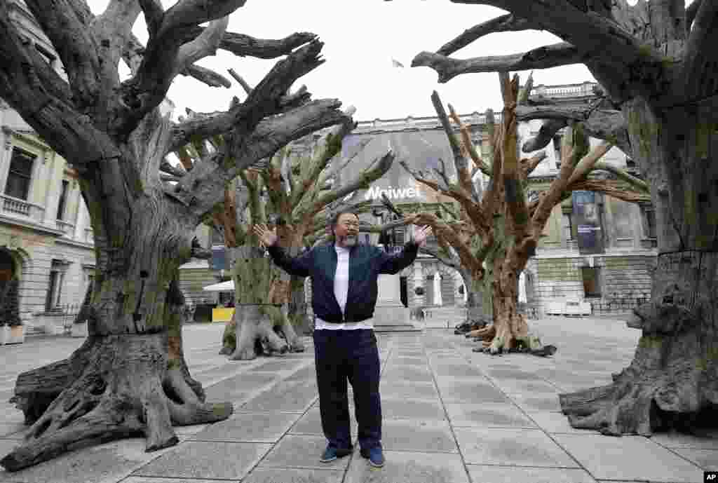 Chinese artist Ai Weiwei poses for photographers with one of his pieces at the Royal Academy of Arts in London.