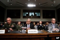 Defense Secretary Jim Mattis, center, flanked by Joint Chiefs Chairman Gen. Joseph Dunford, left, and Defense Undersecretary David Norquist, prepares to testify on Capitol Hill in Washington, June 13, 2017, before a Senate Armed Services Committee hearing