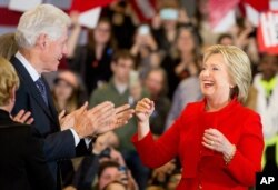 Democratic presidential candidate Hillary Clinton, accompanied by her husband, former President Bill Clinton, arrives at her caucus night rally at Drake University in Des Moines, Iowa, Feb. 1, 2016.