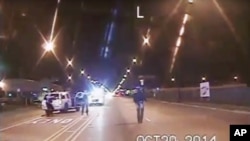 A frame grab from dash-cam video provided by the Chicago Police Department shows Laquan McDonald (R) walks down the street moments before being shot by officer Jason Van Dyke on Oct. 20, 2015.