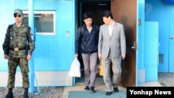 북한에 억류되었던 한국 국적 미 유학생 주원문 씨(가운데)가 5일 판문점 을 통해 돌아오고 있다.