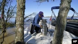 Andre Rabay, research scientist for the LSU Department of Oceanography and Coastal Science, prepares a canister of liquid nitrogen that he will use to freeze samples of the ground on Mike Island, part of the Wax Lake Delta in the Atchafalaya Basin, in St.