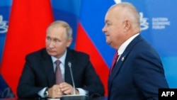 Russia's state news agency Rossiya Segodnya head Dmitry Kiselyov and Russian President Vladimir Putin attend a signing ceremony following the Russian-Chinese talks on the sidelines of the Eastern Economic Forum in Vladivostok, Sept. 11, 2018. 