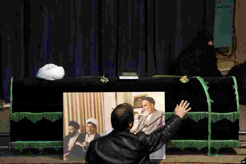 A man touches the coffin of former Iranian President Akbar Hashemi Rafsanjani, at the Jamaran mosque in north Tehran, Iran. Rafsanjani died at age 82 after suffering a heart attack.