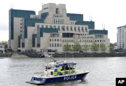 FILE - A police boat patrols on the River Thames near the building of British Secret Intelligence Service, SIS, also known as MI6, in London.