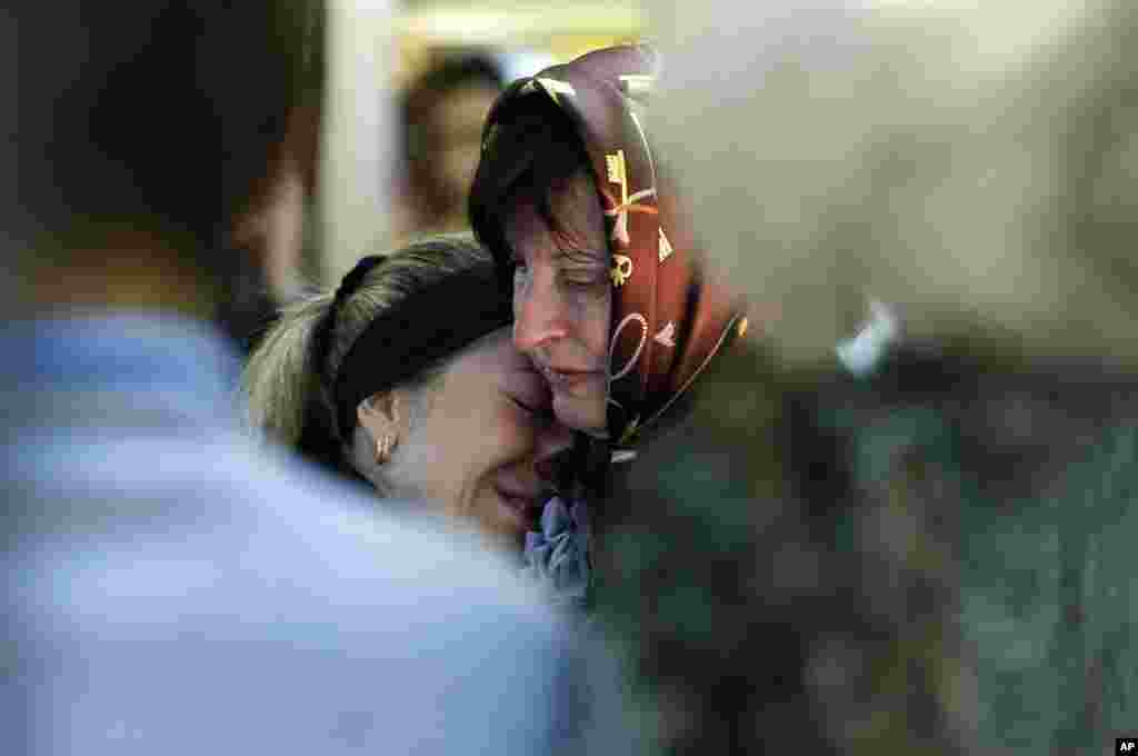 Relatives mourn in front of the casket of a person killed during clashes between Ukrainian and pro-Russian forces last week, during a commemoration service in the center of Slovyansk, eastern Ukraine, Wednesday, May 7, 2014. The U.S. and European nations have increased diplomatic efforts ahead of Ukraine's May 25 presidential election, as a pro-Russian insurgency continues to rock the country's eastern regions. (AP Photo/Darko Vojinovic)