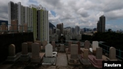 Headstones stand at a cemetery facing residential apartments in downtown Hong Kong, May 29, 2014