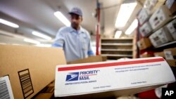 FILE - Packages wait to be sorted in a post office in Atlanta, Feb. 7, 2013.
