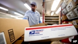 FILE - Packages wait to be sorted in a post office in Atlanta, Feb. 7, 2013.