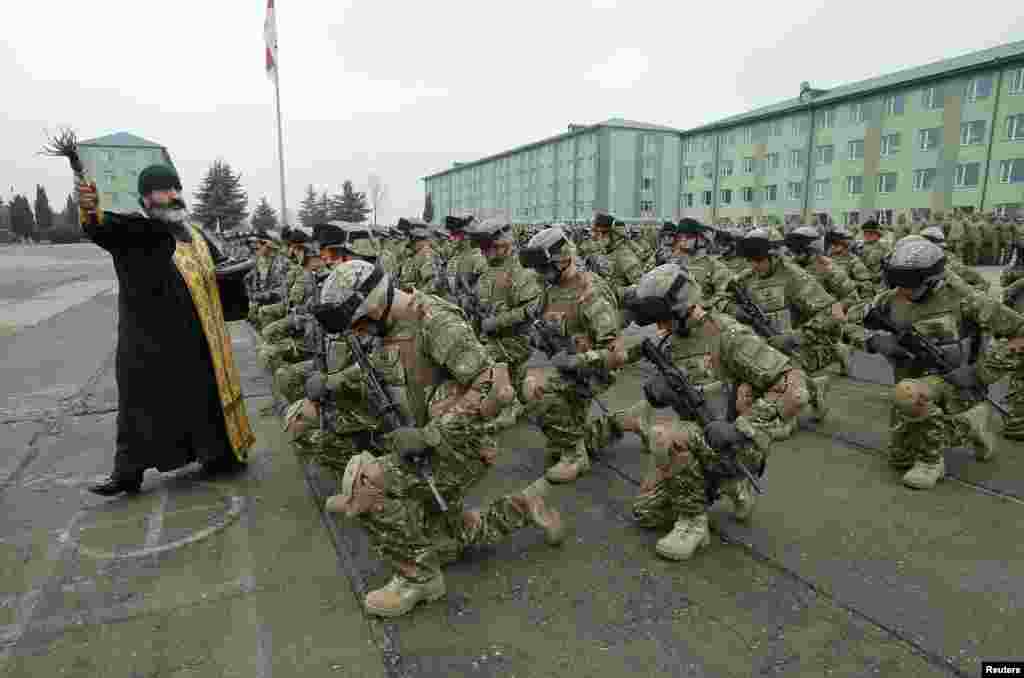 A priest blesses servicemen during a farewell ceremony at the Vaziani military base outside Tbilisi, Georgia.