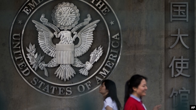 Chinese women walk into the visa application section of the U.S. Embassy in Beijing Friday, May 31, 2013. (AP Photo/Andy Wong)