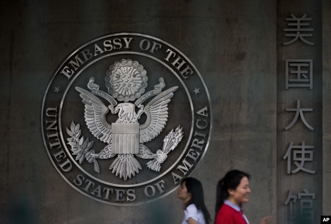Chinese women walk into the visa application section of the U.S. Embassy in Beijing Friday, May 31, 2013. (AP Photo/Andy Wong)