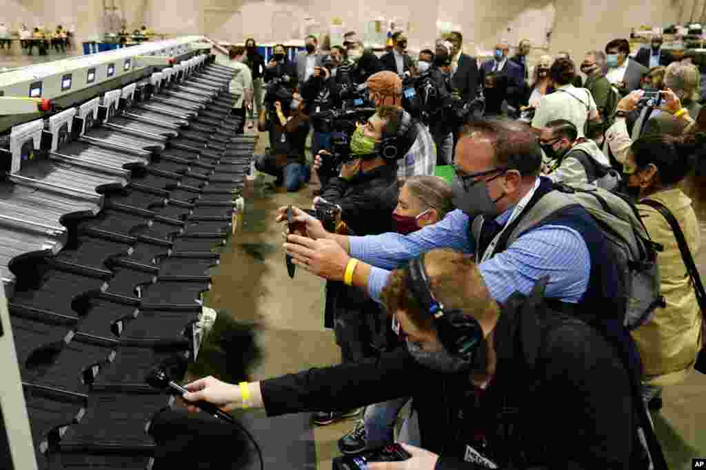 Media members photograph and record a sorting machine at Philadelphia's mail-in ballot sorting and counting center in preparation for the 2020 U.S. general election, Monday, Oct. 26, 2020, in Philadelphia. (AP Photo/Matt Slocum)