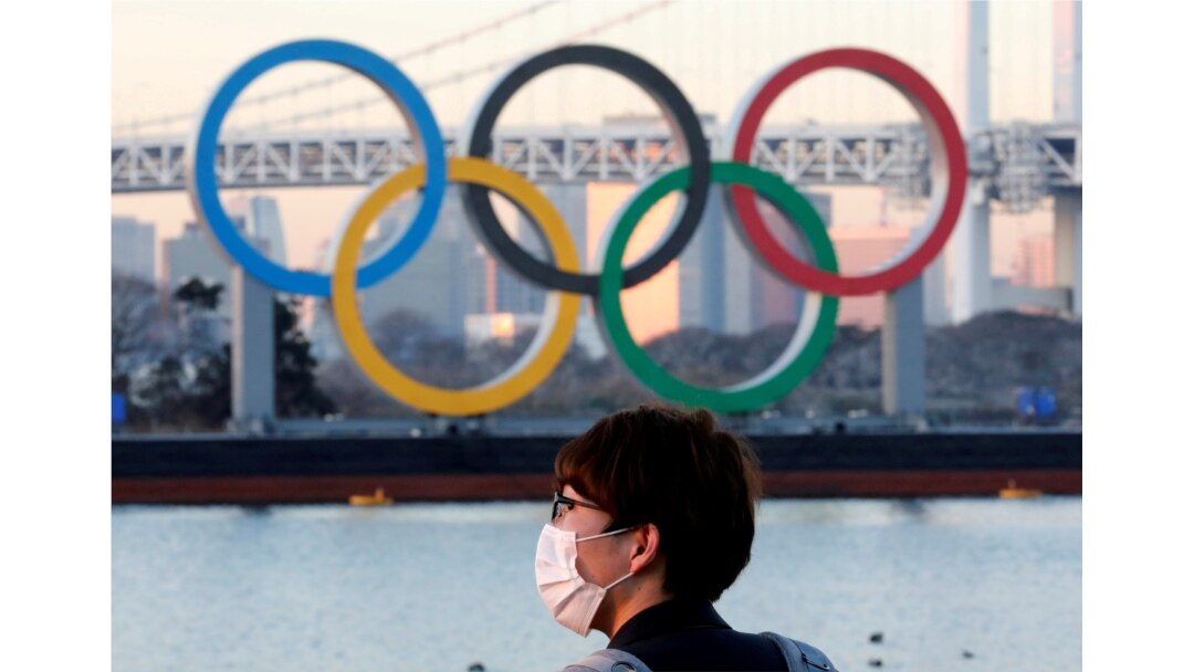 Seorang pria mengenakan masker di tengah pandemi COVID-19 di depan arena Cincin Olimpiade raksasa di Tokyo, Jepang, 13 Januari 2021. (REUTERS / Kim Kyung-Hoon)