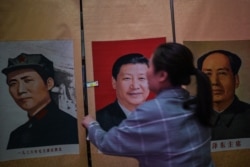 陕西延安东方红大剧院的工作人员在调整习近平和毛泽东的图像(2021年5月10日)