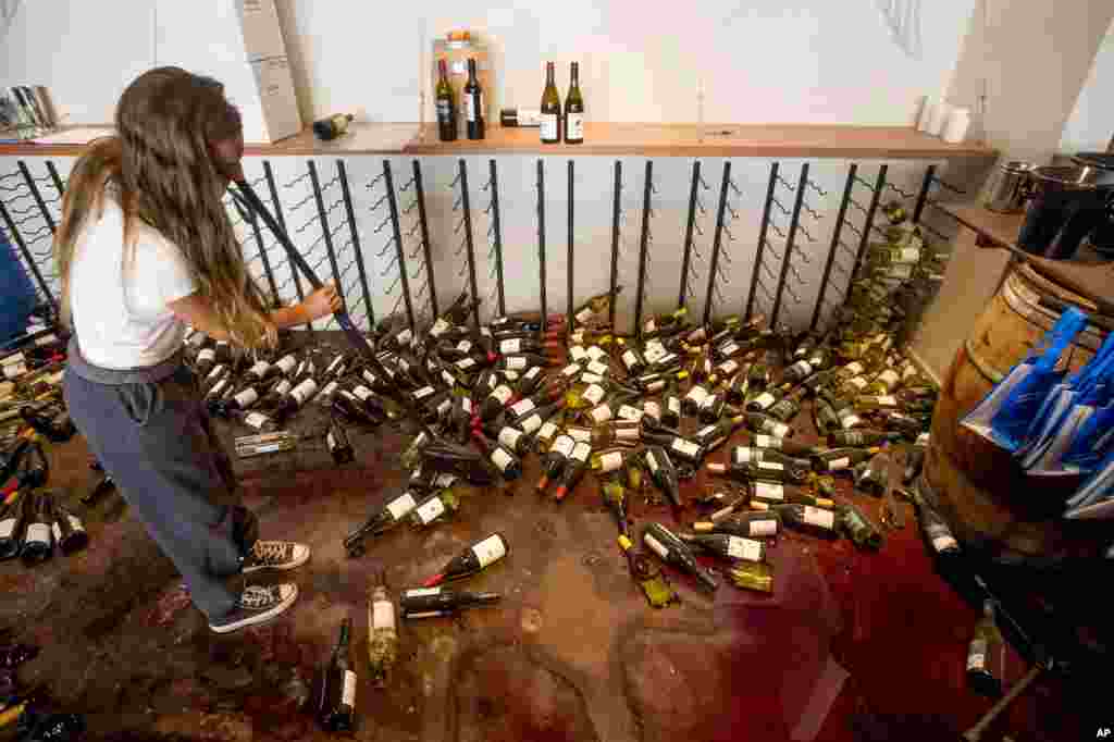 Grace Hardy cleans up wine bottles at nakedwines.com in Napa, California, following an earthquake, Aug. 24, 2014. 