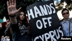 Protesters take part in an anti-bailout rally outside the parliament in Nicosia March 18, 2013