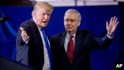 President Donald Trump invites Senate Majority Leader Mitch McConnell, of Ky., right, onstage as he speaks at a rally at Alumni Coliseum in Richmond, Ky., Oct. 13, 2018.