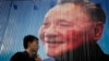 2010年10月21日，中国上海人们走过已故中国领导人邓小平的广告牌。 