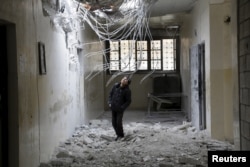 FILE - A boy inspects damage inside his school, due to what activists said was an airstrike carried out the previous day by the Russian air force in Injara town, Aleppo countryside, Syria, Jan. 12, 2016.