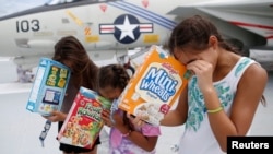 Michelle Campano (Right) and her sisters Jennifer (Middle) and Lauren Campano, all of Rockville, Maryland, check on the position of the sun using homemade solar viewers from the flight deck of the Naval museum ship U.S.S. Yorktown during the Great America