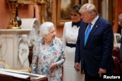 Britanska kraljica Elizabeta II gleda izložene američke predmete u kraljevskoj kolekciji, zajedno as predsednikom SAD Donaldom Trampom, u Londonu, 3. juna 2019.