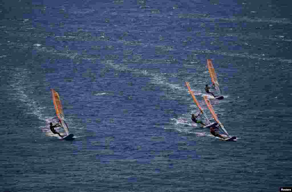 Windsurfers compete near the coast of the Athens Riviera in Greece.