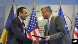 US Assistant Secretary of State Philip Gordon (L) shakes hand with Kosovo Prime Minister Hashim Thaci after signing an agreement to support education authorities in capital Pristina, June 16, 2011
