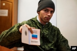 FILE - A Russia-backed rebel shows a passport issued by the self-proclaimed Luhansk Peoples Republic, in Luhansk, eastern Ukraine, Oct. 27, 2015.