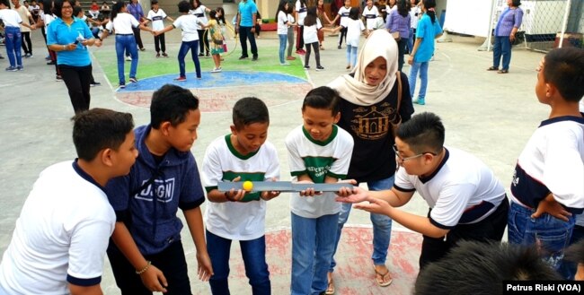 Siswa-siswi dari Madrasah Ibtidaiyah (MI) Islamiyyah-Plosogenuk, SD Kristen Petra, SD Katolik Wijana, dan sejumlah anak SD anggota jemaat GKJW Bongsorejo, bermain bersama sambil menanti waktu berbuka puasa (Foto:VOA/Petrus Riski).