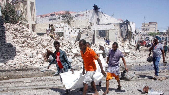 Rescuers carry away the dead body of a civilian who was killed in a blast in Mogadishu, Somalia, Jan. 12, 2022.