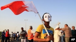 Bahraini anti-government protesters, including a masked boy carrying a national flag, gather for a march in A'ali, Bahrain, April 12, 2013. 