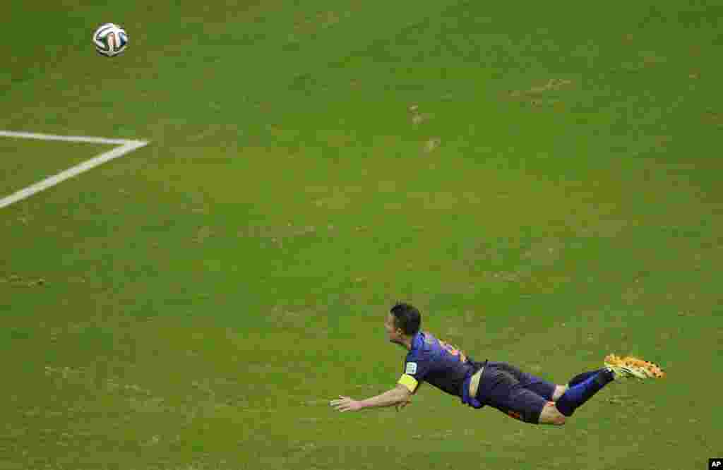 Robin van Persie dari Belanda melompat sambil menyundul bola, seolah-olah seperti melayang di udara, yang berhasil masuk ke gawang lawan saat pertandingan dengan Spanyol di Arena Ponte Nova in Salvador, Brazil (13/6). (AP/Christophe Ena)