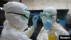 Nhân viên y tế Liberia mặc quần áo bảo hộ trước khi di chuển thi hài người bị nhiểm virut Ebola