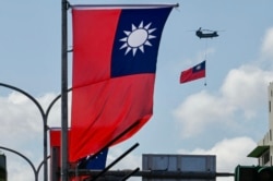 FILE - A CH-47 Chinook helicopter carries a Taiwan flag during national day celebrations in Taipei on Oct. 10, 2021.