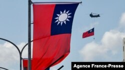 FILE - A CH-47 Chinook helicopter carries a Taiwan flag during national day celebrations in Taipei on Oct. 10, 2021.