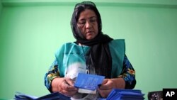 Independent Election Commission (IEC) employee counts the ballot at a polling station in Mazar-i-Sharif, Afghanistan, June 14, 2014. 