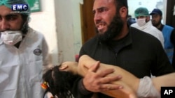خان شیخون حملے کے بعد ایک شخص حملے سے متاثرہ اپنی بچی کو اسپتال لارہا ہے (فائل فوٹو)
