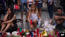 A girl places a candle after a terror attack that killed 14 people and wounded over 120 in Barcelona, Spain, Aug. 20, 2017. (