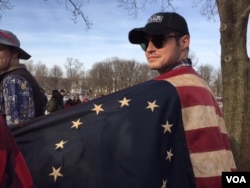 Some wore old-fashioned flags, others wore red "Make America Great Again" hats to hear the president elect's first greeting of the inauguration. (C. Presutti/VOA)