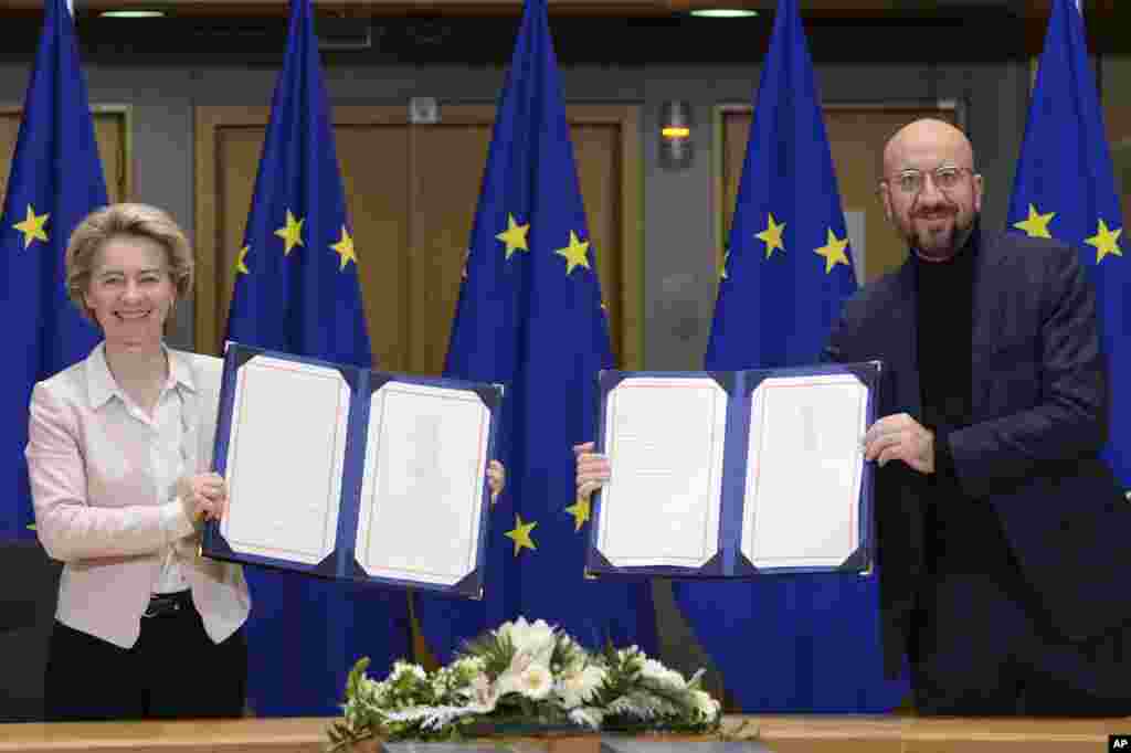 European Commission President Ursula von der Leyen, left, and European Council President Charles Michel show the signed EU-UK Trade and Cooperation Agreement at the European Council headquarters in Brussels, Belgium.