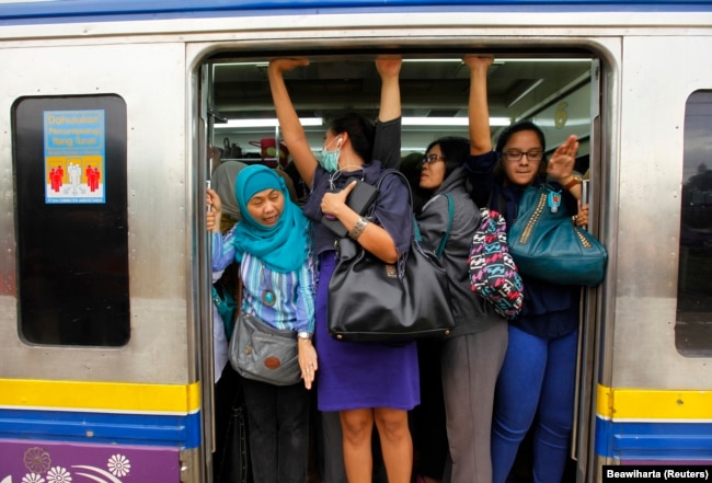 Perempuan yang akan bekerja terlihat berdesak-desakan di gerbong kereta api di stasiun kereta Sudimara di pinggiran Jakarta 3 Juni 2013. (Foto: REUTERS/Beawiharta)