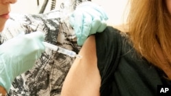 FILE - This photo from the National Institute of Allergy and Infectious Diseases shows a woman receiving a dose of the NIAID/GSK Ebola vaccine at the NIH Clinical Center in Bethesda, Maryland, September 2014.